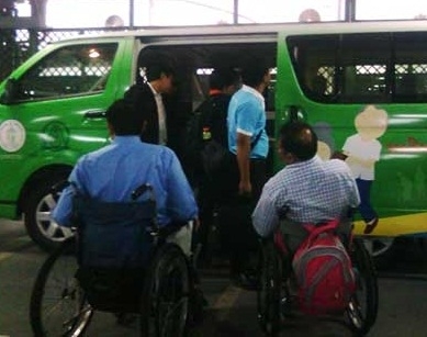 คนพิการนั่งรถเข็น กำลังใช้บริการรถตู้สำหรับคนพิการ