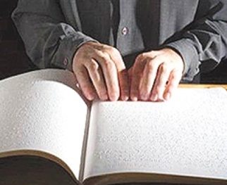ผู้พิการทางสายตากำลังอ่านหนังสืออักษรเบล