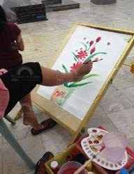 นางสาวรุ่งลาวัน  คาริก  สาวพิการแขนด้วนสองข้างกำลังวาดภาพด้วยเท้า