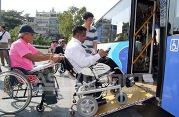 คนพิการนั่งรถเข็นใช้ทางลาดขึ้นรถเมล์