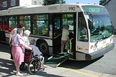 ผู้สูงอายุนั่งรถเข็นใช้ทางลาดขึ้นรถเมล์