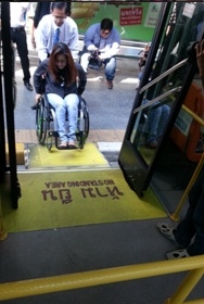 คนพิการนั่งรถเข็น เข็นรถขึ้นทางลาดรถเมล์ชานต่ำ