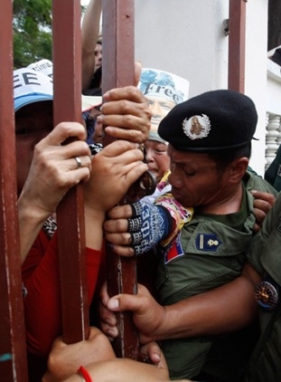 ภาพ ตำรวจประเทศกัมพูชาพยายามปิดประตูไม่ให้ผู้ชุมนุมเข้าประตูได้