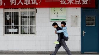 วัยรุ่นจีน 2 คน ชื่อ Xie Xu และเพื่อนผู้พิการ ชื่อ Zhang Chi อุ้มเพื่อนผู้พิการไปเรียนทุกวัน