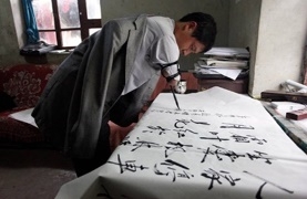 ครูเจียง กำลังเขียนตัวอักษรจีนบนกระดาษ