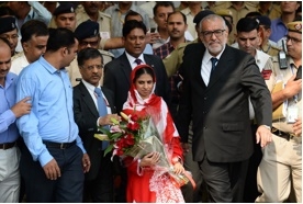 คีตา ยิ้มรับช่อดอกไม้จากเจ้าหน้าที่อินเดีย หลังเดินทางถึงสนามบินนานาชาติ อินทิรา คานธี ในกรุงนิวเดลี