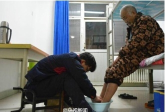 นายจ้าว เต๋อหลง กำลังล่างเท้าให้พ่อ