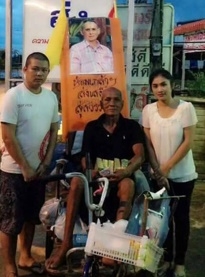 นายปาน หมื่นโยชน์ พ่อเฒ่าพิการเดินไม่ได้วัย 84 ปี นั่งรถสามล้อแบบคันโยกพระราชทาน ติดรูปพระบรมฉายาลักษณ์ และสวมเสื้อสีดำไว้ทุกข์ที่มีข้อความ “ขอเป็นข้ารองพระบาททุกชาติไทย”