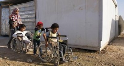 Above: With the help of their sister and brother Marva, 12 (left) and Mahar, 11, make their way home in the Zaatari camp for Syrian refugees in Jordan.