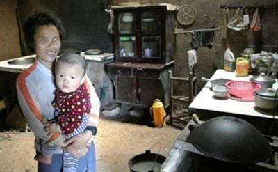 หญิงชาวจีนพิการตาบอดอุ้มลูกน้อยอยู่ภายในบ้าน
