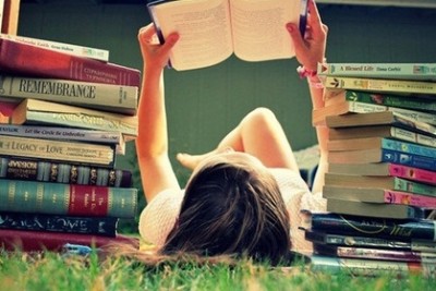 ภาพประกอบจากอินเทอร์เน็ต เด็กหญิงกำลังนอนอ่านหนังสือที่กลางสนามหญ้า