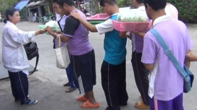 เด็กนักเรียนพิการทางสายตารวมกลุ่มเดินเกาะไหล่-เกาะแขนถือไม้เท้าขายผักปลอดสาร