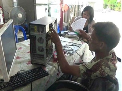 หน้าที่คนพิการในชมรมคนพิการนครตรัง กำลังซ่อมคอมพิวเตอร์