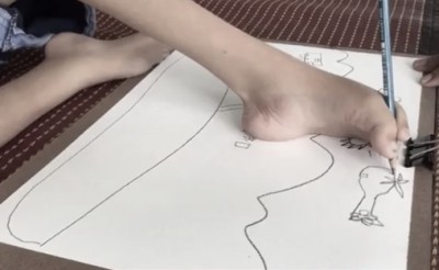 เด็กชายพิสิษฐ์ นารี หรือน้องยูโร อายุ 9 ปี เด็กนักเรียนชั้นประถมศึกษาปีที่ 2 เรียนศิลปะใช้เท้าวาดรูป